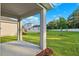 View from covered backyard patio overlooking a beautiful, landscaped lawn and trees at 6035 Nikki Ln, Odessa, FL 33556