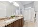Bathroom featuring dual vanities, granite counters, and shower at 6035 Nikki Ln, Odessa, FL 33556