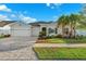 Charming home boasts a three-car garage, manicured lawn, and meticulously laid paver driveway at 6035 Nikki Ln, Odessa, FL 33556