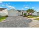 Charming home boasts a three-car garage and meticulously laid paver driveway with lush front lawn at 6035 Nikki Ln, Odessa, FL 33556