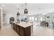 Open kitchen with island and barstool seating flowing into living and dining areas at 6035 Nikki Ln, Odessa, FL 33556