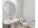 Charming powder room features a pedestal sink with an oval mirror, a toilet, and neutral wall color at 6035 Nikki Ln, Odessa, FL 33556
