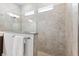 Elegant shower with stone tile and glass door featuring granite counter and a towel bar at 6035 Nikki Ln, Odessa, FL 33556