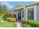 Inviting front entrance with a decorative door, surrounded by lush greenery and large windows at 6041 Sandhill Ridge Dr, Lithia, FL 33547