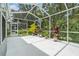 The screen enclosed patio, view of the yard, potted plants, and nearby pool at 6041 Sandhill Ridge Dr, Lithia, FL 33547