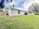 Home featuring a backyard with grass, privacy fence, and a patio with table and chairs at 630 Timber Bay W Cir, Oldsmar, FL 34677