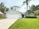 Charming single-story home featuring a well-manicured lawn and a two-car garage at 630 Timber Bay W Cir, Oldsmar, FL 34677