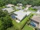 Aerial view of a home with a tile roof, screened-in pool and lush landscaping at 6905 Arabian Rd, Odessa, FL 33556