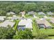 Aerial view of a home with a tile roof, screened-in pool and mature landscaping at 6905 Arabian Rd, Odessa, FL 33556
