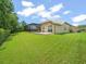 Landscaped backyard with lush green lawn, screened-in lanai and plenty of privacy at 6905 Arabian Rd, Odessa, FL 33556