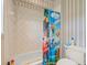 Bathroom featuring colorful character-themed shower curtain, toilet and tile walls at 6905 Arabian Rd, Odessa, FL 33556