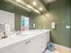 Bathroom featuring double sinks, white tiled countertop, and wallpaper at 6905 Arabian Rd, Odessa, FL 33556