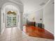 Open-concept dining room with wood floors, an elegant chandelier, and arched entryway at 6905 Arabian Rd, Odessa, FL 33556
