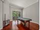 Game room with hardwood floors and view to a pool and outdoor patio at 6905 Arabian Rd, Odessa, FL 33556