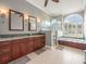 Beautiful main bathroom with double vanity, soaking tub, walk-in shower and arched window at 6905 Arabian Rd, Odessa, FL 33556