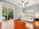 Spacious main bedroom featuring hardwood floors, ceiling fan, slider to lanai, and lots of natural light at 6905 Arabian Rd, Odessa, FL 33556