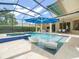 Screened in pool area with clear blue swimming pool, in-ground spa, and comfortable outdoor seating at 6905 Arabian Rd, Odessa, FL 33556