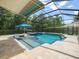 Inviting screened in pool area with an in-ground spa, outdoor furniture, and serene blue pool at 6905 Arabian Rd, Odessa, FL 33556
