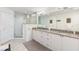 Bathroom featuring double granite vanity, large mirror, and walk-in marble tiled shower at 706 Bayway Blvd # 503, Clearwater, FL 33767