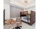 Bedroom with a wooden desk, chair, and bunk bed, complemented by a blind-covered window at 706 Bayway Blvd # 503, Clearwater, FL 33767
