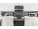 Close-up of kitchen area, showcasing stainless steel oven and microwave, and designer backsplash at 706 Bayway Blvd # 503, Clearwater, FL 33767