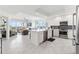 Open-concept kitchen with white cabinets, quartz countertops, stainless steel appliances and spacious island at 706 Bayway Blvd # 503, Clearwater, FL 33767