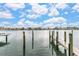 Waterfront home featuring a private dock with views of luxurious homes across the bay under a bright blue, partially cloudy sky at 706 Bayway Blvd # 503, Clearwater, FL 33767