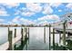 Waterfront home featuring a private boat dock with boat lift and boat with views of luxurious homes across the bay at 706 Bayway Blvd # 503, Clearwater, FL 33767