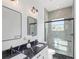 Sleek bathroom with double sinks, black marble countertops, a glass shower, and modern lighting fixtures at 711 42Nd S Ave, St Petersburg, FL 33705