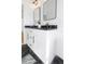 Bathroom with double sinks, black marble countertops, and modern black fixtures, complemented by marble flooring at 711 42Nd S Ave, St Petersburg, FL 33705