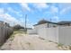 View of the garage exterior, white privacy fence, and gravel driveway at 711 42Nd S Ave, St Petersburg, FL 33705