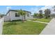 Angle shot of a home's front exterior, showcasing lush lawn, modern design, and the charming walkway to the entrance at 711 42Nd S Ave, St Petersburg, FL 33705