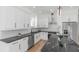 A bright kitchen features white cabinets, stainless steel appliances, and black marble countertops and island at 711 42Nd S Ave, St Petersburg, FL 33705