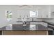 Bright kitchen featuring white cabinets, black hardware, stainless steel appliances, and a black marble island at 711 42Nd S Ave, St Petersburg, FL 33705