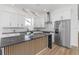 A bright kitchen featuring white cabinets, stainless steel appliances, black marble counters, and a wood trimmed island at 711 42Nd S Ave, St Petersburg, FL 33705