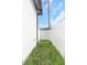 Narrow side yard with grass between a white home exterior and a white fence at 711 42Nd S Ave, St Petersburg, FL 33705