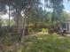 Shaded backyard with mature trees, lush grass, and weathered chairs at 729 41St St, Sarasota, FL 34234
