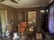 Cluttered living room with wood paneling, furniture, and a ceiling fan at 729 41St St, Sarasota, FL 34234
