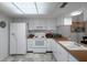 Well-lit kitchen featuring white appliances, ample counter space, and tiled flooring at 7433 Greystone Dr # 7433, Hudson, FL 34667