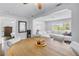 Open-concept dining room with wood table and white upholstered chairs, flowing into living area with lots of natural light at 774 40Th Ne Ave, St Petersburg, FL 33703