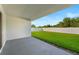 Covered back patio with a view of the lush green lawn and white vinyl fence at 8840 Mugnai St, Riverview, FL 33578