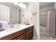 Well-lit bathroom features a wood vanity, white countertop, a large mirror with butterfly decor at 8840 Mugnai St, Riverview, FL 33578
