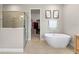 Luxurious bathroom featuring a soaking tub, glass shower, and access to a walk-in closet at 8840 Mugnai St, Riverview, FL 33578