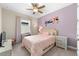 Bright bedroom features a floral wall decor, a bed with pink bedding, and a neutral carpet at 8840 Mugnai St, Riverview, FL 33578