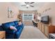 Comfortable bedroom featuring a blue sofa, a window, and a decorative shelf at 8840 Mugnai St, Riverview, FL 33578