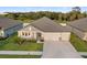 Aerial shot of home with a three-car garage, mature landscaping, and neutral color palette at 8840 Mugnai St, Riverview, FL 33578