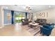 Comfortable living room features two sofas, a modern coffee table, and sliding glass doors to the backyard at 8840 Mugnai St, Riverview, FL 33578
