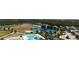 Scenic aerial view of community amenities featuring a pool, tennis courts, and open green spaces at 8922 Little Bluestem Dr, Land O Lakes, FL 34637