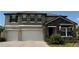Beautiful two-story home featuring a two-car garage, stone accents, and manicured landscaping at 8922 Little Bluestem Dr, Land O Lakes, FL 34637