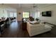 Spacious living room with dark hardwood floors, a ceiling fan, and sliding glass doors at 8922 Little Bluestem Dr, Land O Lakes, FL 34637